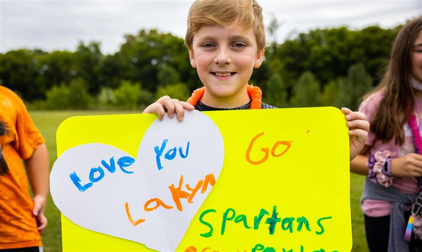 A student holds a sign reading I Love Summit High